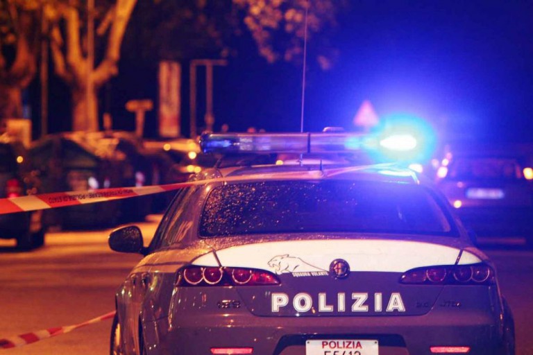 Foto di auto della polizia di stato in notturna, con le sirene accese