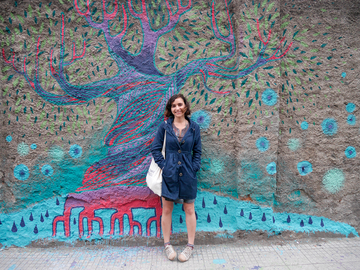 L'artista siriana Diala Brisly di fronte al suo murale in via XXIV maggio - messina