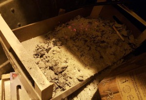 foto di una cassetta di legno con all'interno cenere ancora infiammata. MessinaServizi Bene Comune segnala il rischiato incendio di un cassone