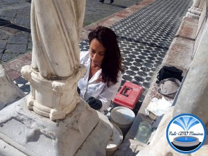 la restauratrice fedra sciacca mentre pulisce le colonne del duomo imbrattate da una scritta con pennarello nero indelebile