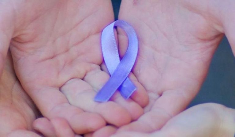 Mani che tengono un fiocchetto lilla, simbolo della giornata sui disturbi alimentari