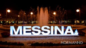Foto della scritta "Messina" illuminata nella piazza della Stazione Centrale