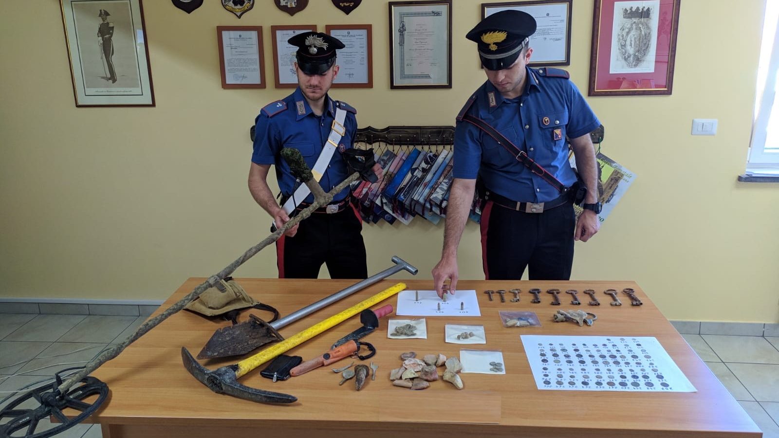 carabinieri che mostrano il materiale sequestrato