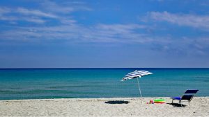 foto di una spiaggia con sdraio e ombrellone