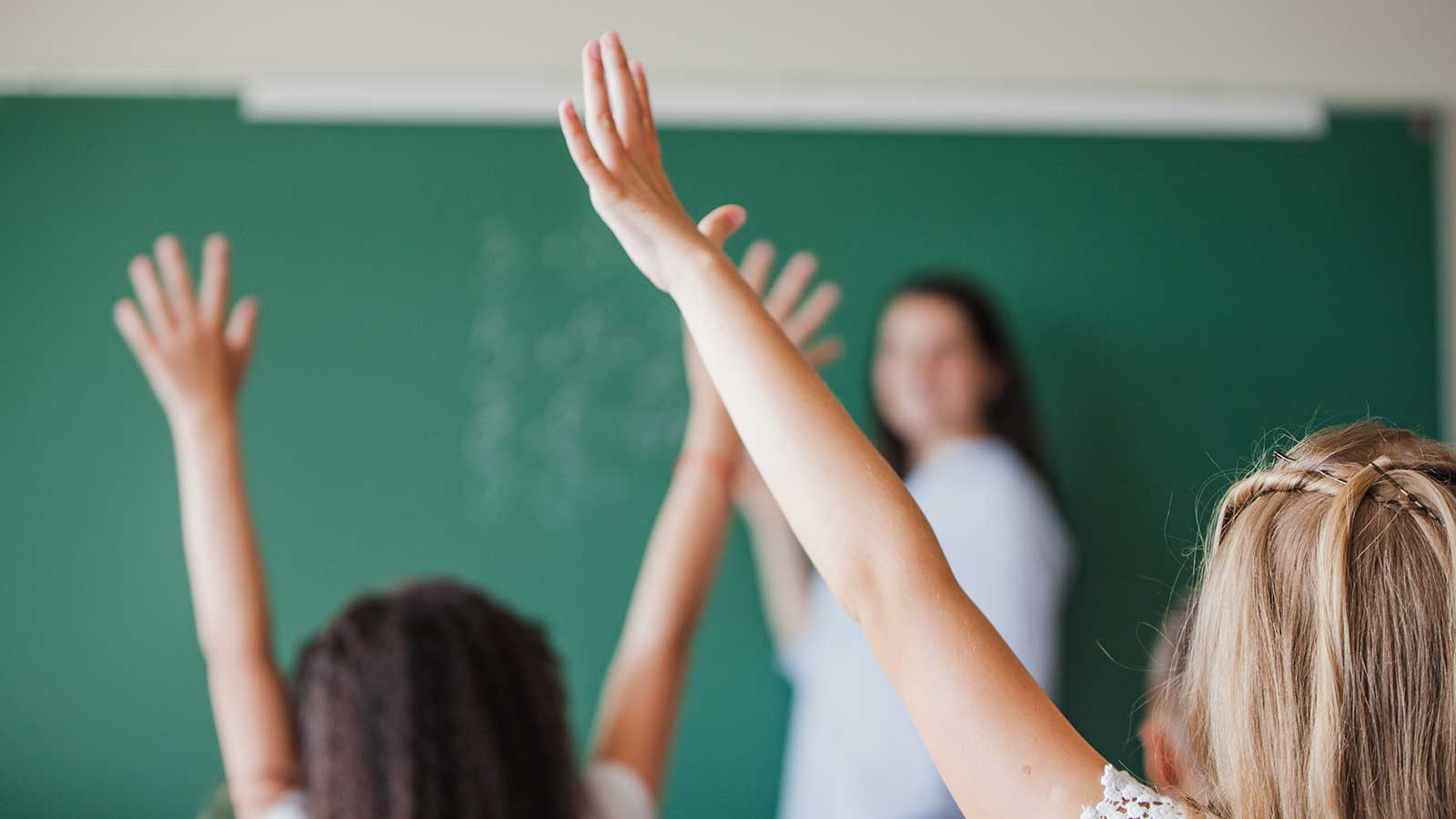bambini che alzano la mano a scuola