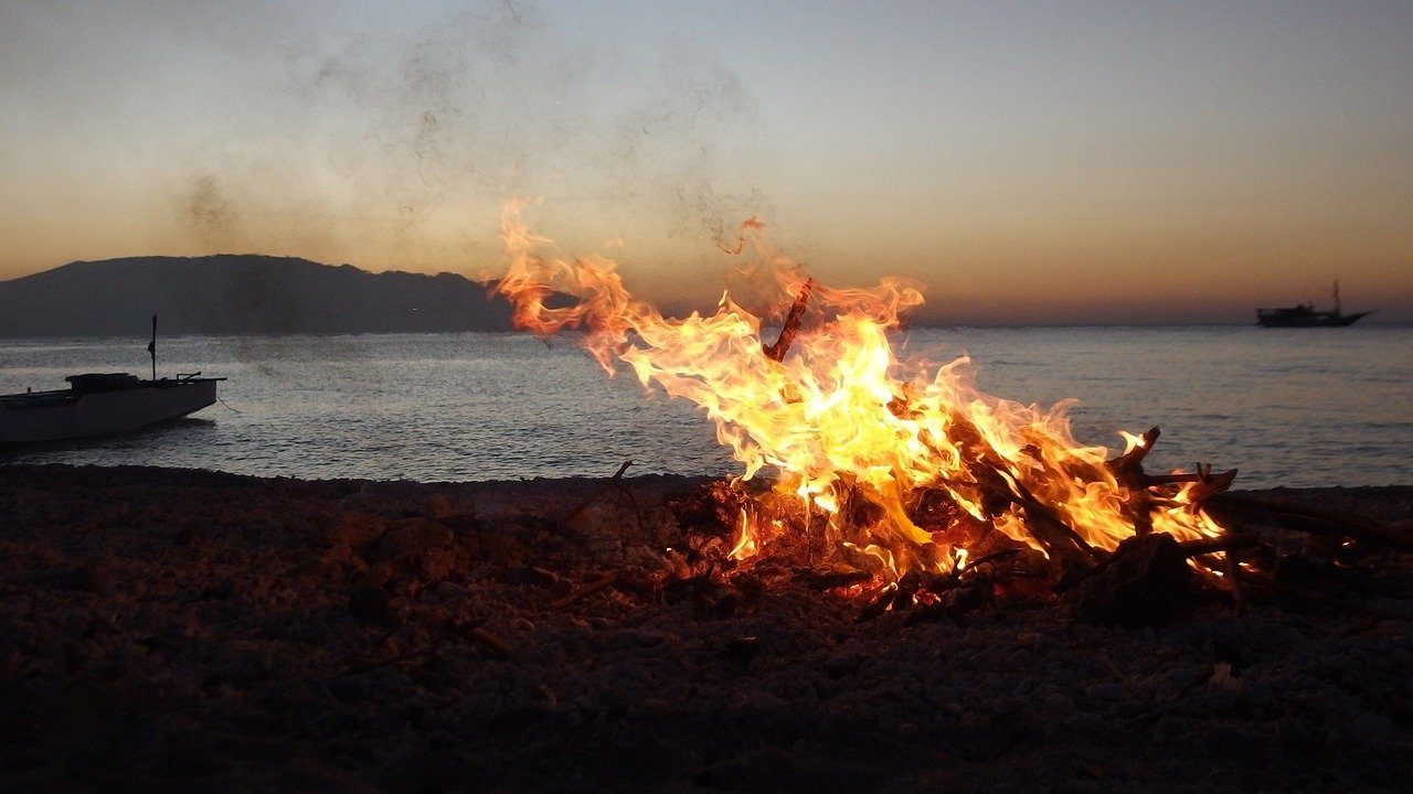 foto di un falò di sera sulla spiaggia