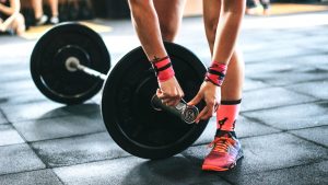 persona che sistema i pesi in palestra